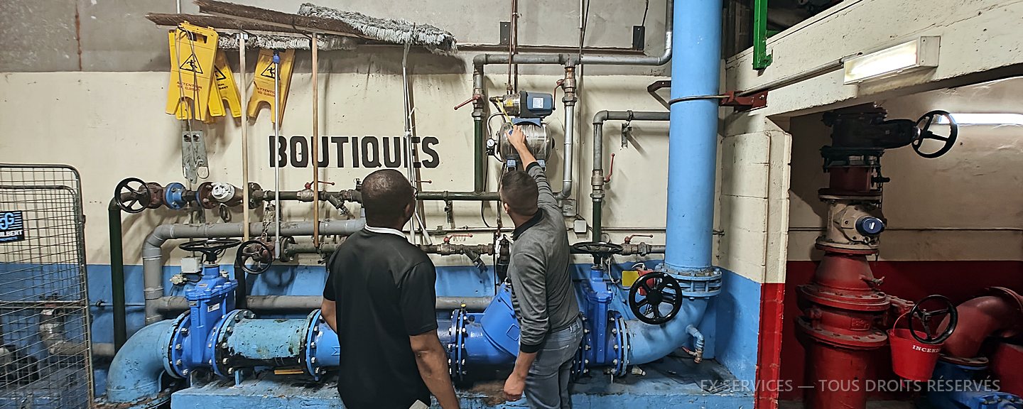 Deux techniciens FX Services intervenant sur un réseau de distribution en local technique